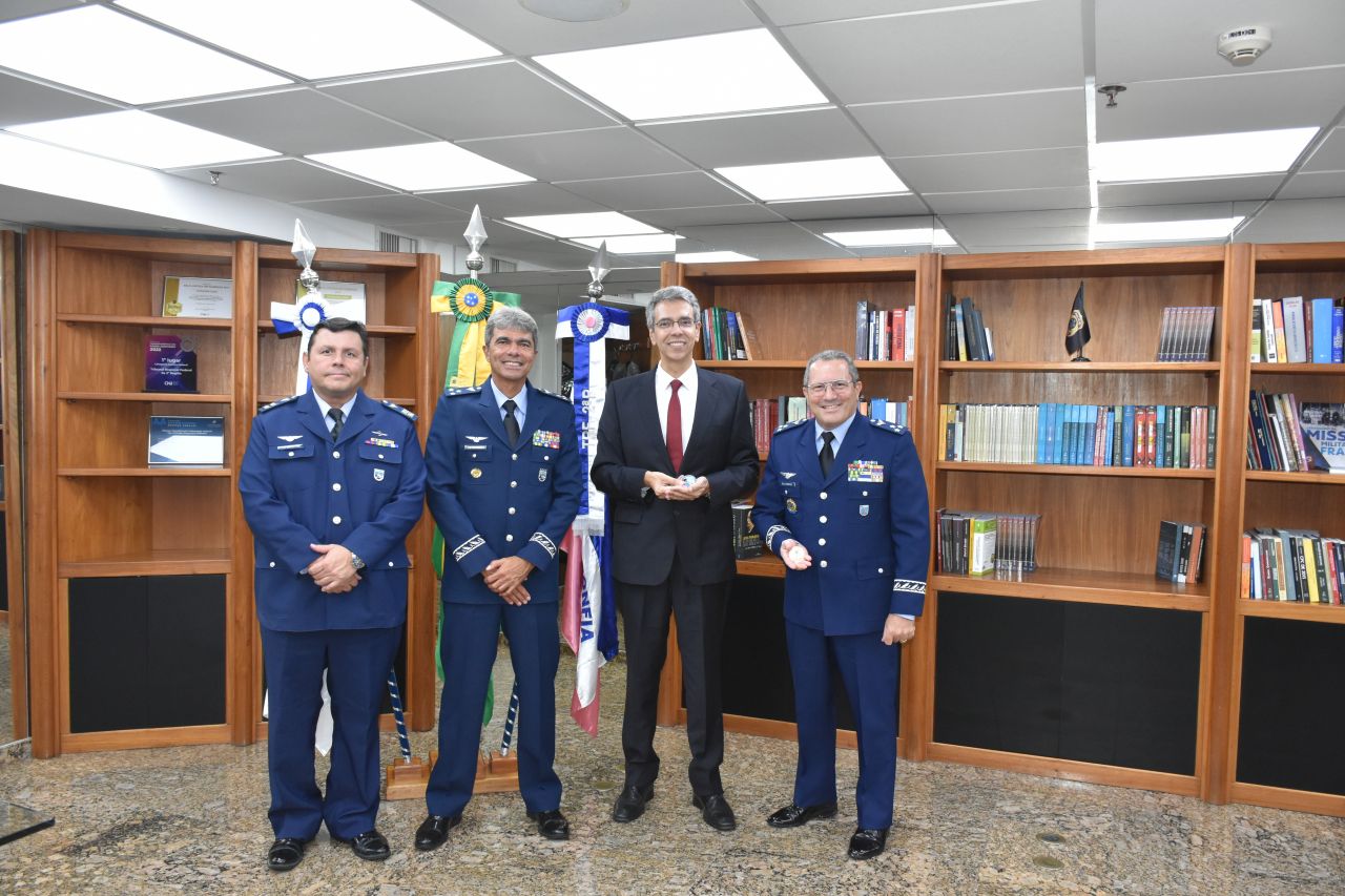 Na foto posada, Guilherme Calmon os presenteia com a moeda institucional do TRF2 e recebe dos visitantes uma moeda do III COMAR.